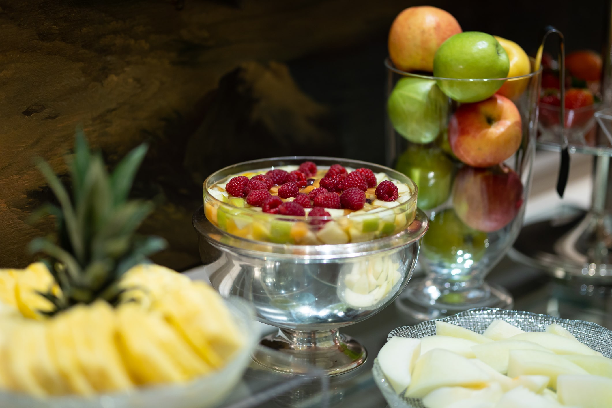 coin fruits frais pour le petit déjeuner avec salade de fruits décorée de framboises et bocal en verre avec des pommes vertes, rouges et jaunes